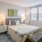 Spacious and well lit bedroom with plush carpet and large windows