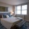 Spacious and well lit bedroom with plush carpet and large windows