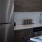 Spacious and well lit kitchen with wood floors and stainless steel appliances. 