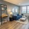 Spacious and well lit living room with wood floors and an open floor plan with access to the kitchen.