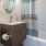 Large well lit bathroom with large mirror and brown cabinets 