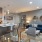 Spacious and well lit living room with wood floors and an open floor plan with access to the kitchen.
